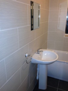 Tlied bathroom wall with sink and mirror