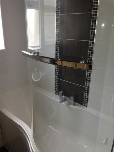 Shower bath with centre taps and featured tiled wall