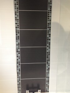 Feature wall eachived by using darker tiles and mosaic tiles