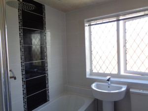 Refitted Bathroom with white tiles and black feature wall