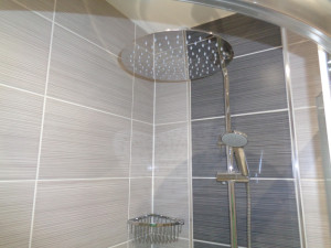Curved quadrant shower tray with thermostatic wall mounted shower