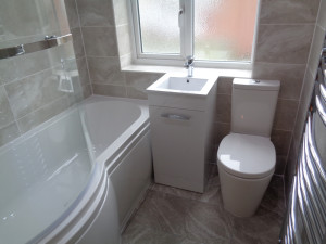 Bathroom fitted with grey wall and floor tiles