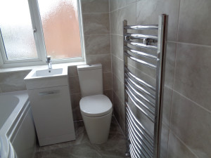 Large Bathroom Towel Warmer Walls and Floor tiled with Round Hay grey tiles