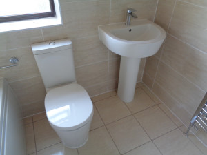Bathroom with modern easy clean toilet and pedestal basin 