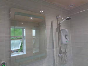 Shower Room With Grey Travertine Tiles, Mirror and Triton Safe Guard Shower