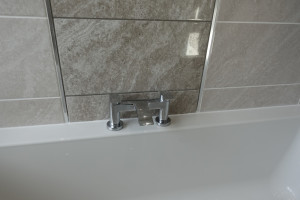 Bathroom finished with a feature wall  and bath taps 