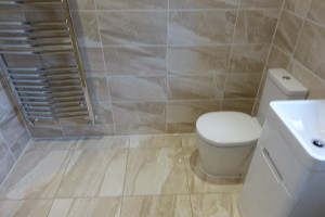 Chrome Bathroom Towel Warmer with Basin and Toilet and Astbury wall and floor Tiles
