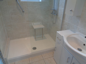Mobility walk in shower with wall mounted shower seat and hand rail