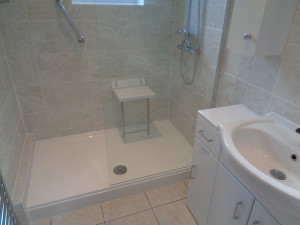 Mobility walk in shower with wall mounted shower seat and hand rail