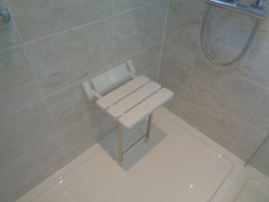 Shower seat fitted to wall in walk in shower area
