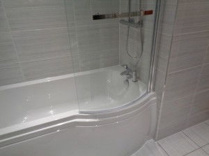 p shaped shower bath with a curved glass shower screen
