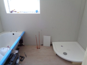 Plaster board added to the bathroom walls with the bath and shower fitted