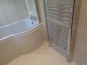 Wall mounted chrome towel radiator and shower bath