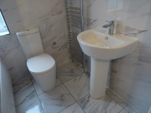 Bathroom fitted with pedestal basin and toilet