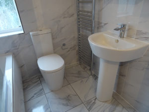 Bathroom with marble effect wall and floor tiles 