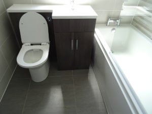 Bathroom fully tiled in Coventry with grey floor tile