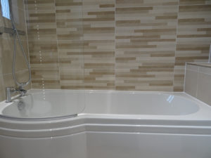 Bathroom with feature tiled bath wall rugby