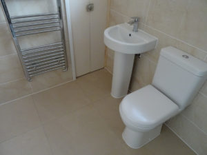 Mobility bathroom with comfort height toilet and basin towel warmer