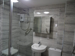 Fully tiled mobility bathroom with wall mirror cabinet