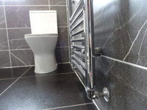 Shower Room with modern toilet and chrome towel warmer