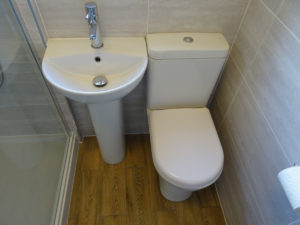 Mobility bathroom walk in shower room with comfort height toilet and pedestal basin
