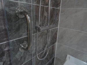 Mobility bathroom with grab rails in the shower area