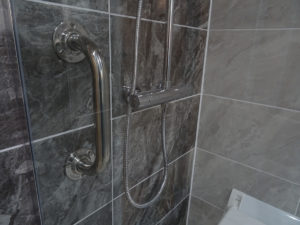 Mobility bathroom with grab rails in the shower area