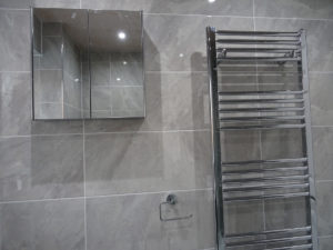 Mobility bathroom with towel warmer and fully tiled