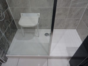 Mobility bathroom with wall mounted shower seat folded down