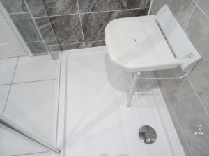 Mobility bathroom with wall mounted shower seat folded up