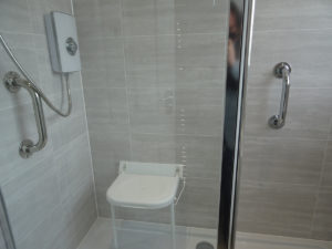 Mobility shower room Coventry with wall mounted shower seat and grab rails